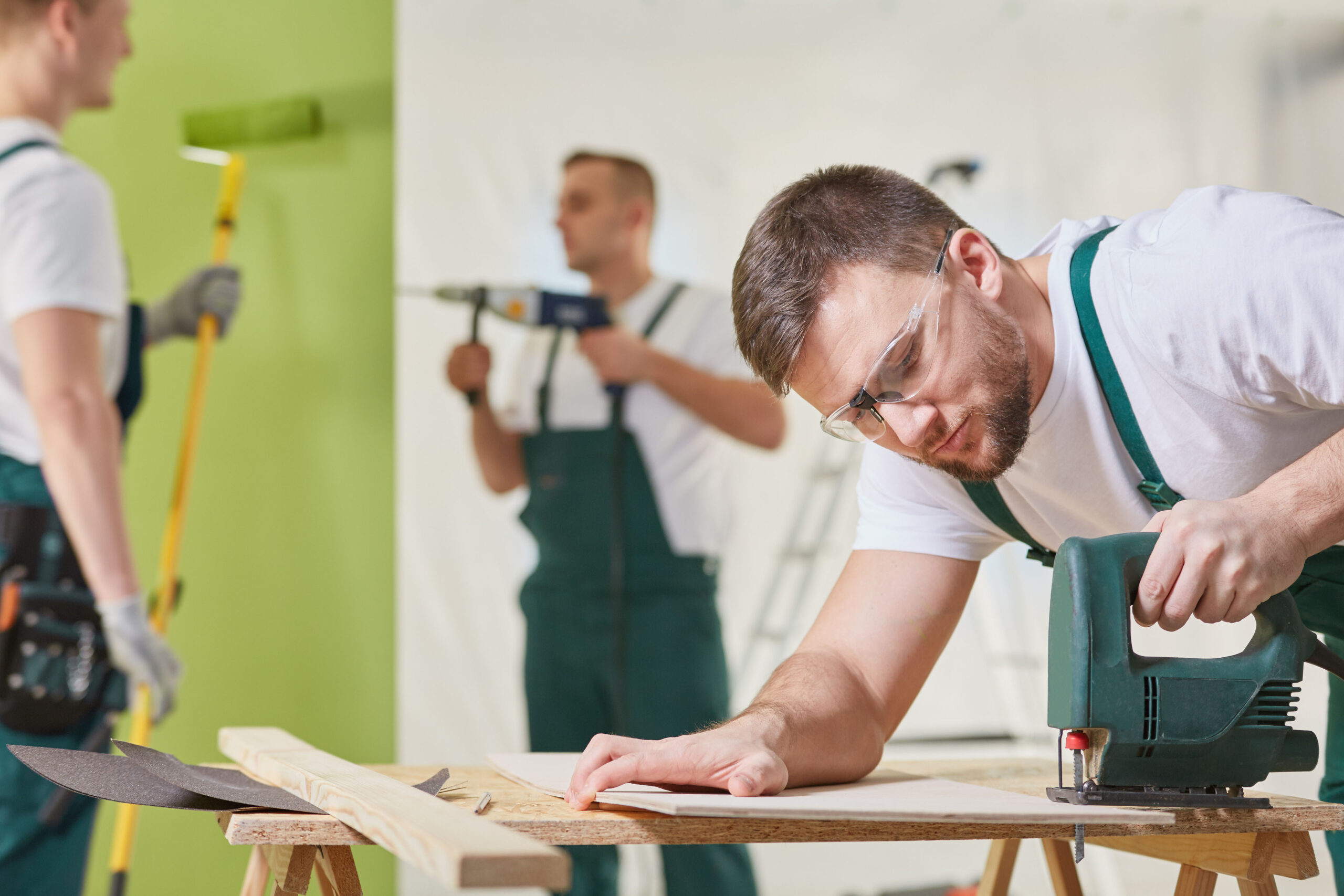 Three workers renovating a room